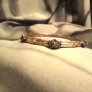Ornate gold tone bangle bracelet w/ stone accents